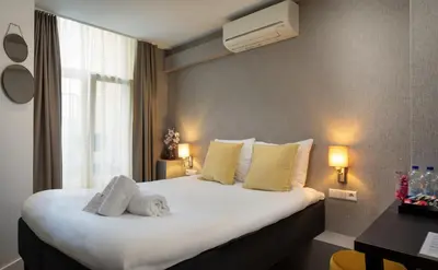 a hotel room with a bed and a window at NL Hotel District Leidseplein in Amsterdam
