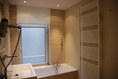 a bathroom with a window and a sink and a shower at NL Hotel District Leidseplein in Amsterdam