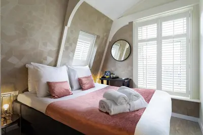 a bedroom with a bed with two towels on it at NL Hotel District Leidseplein in Amsterdam