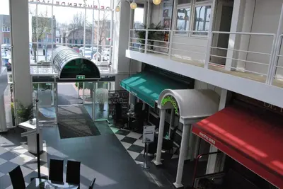 a hallway of a building with a checkered floor at Hotel De Rustende Jager in Nieuw-Vennep