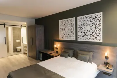 a bedroom with a large bed and a bathroom at Hotel De Rustende Jager in Nieuw-Vennep