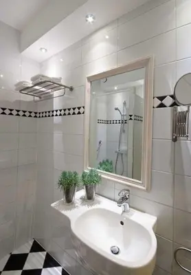 a white bathroom with a sink and a mirror at Hotel De Rustende Jager in Nieuw-Vennep