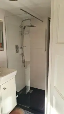 a bathroom with a shower and a black floor at Little Villa Lovely in Bergen