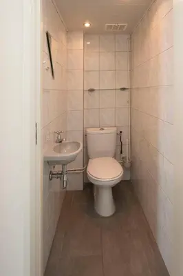 a small bathroom with a toilet and a sink at The Lookout in Egmond aan Zee