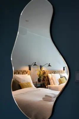 a mirror reflecting a bedroom with two beds at Six Boutique Hotel in Haarlem
