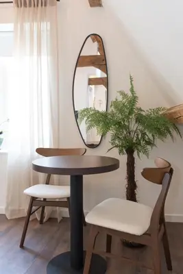 a round table with a mirror and a plant at Six Boutique Hotel in Haarlem