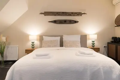a bedroom with a large white bed with two lamps at Six Boutique Hotel in Haarlem