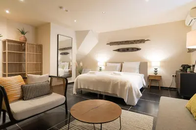 a bedroom with a bed and a living room at Six Boutique Hotel in Haarlem