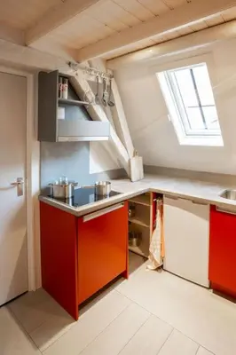 a kitchen with red cabinets and a window at De Kapelle in Oudewater in Oudewater
