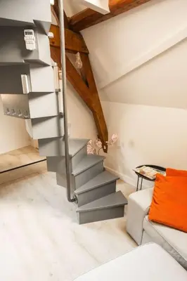 a spiral staircase in a room with a couch at De Kapelle in Oudewater in Oudewater