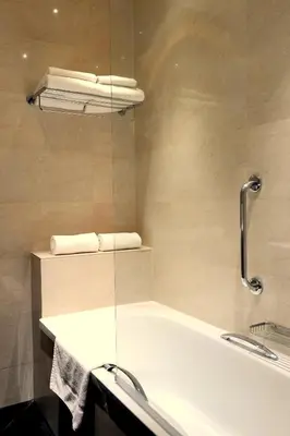 a bathroom with a bath tub with a glass wall at Hotel Sint Nicolaas in Amsterdam