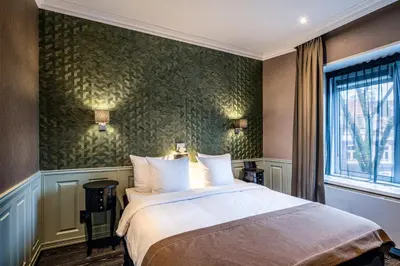 a bedroom with a bed and a green wall at Hotel Sint Nicolaas in Amsterdam