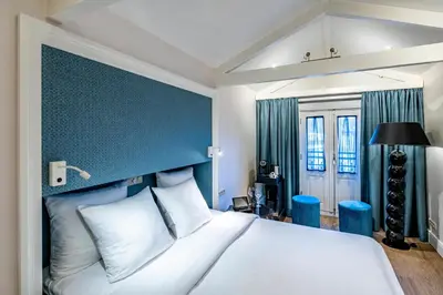 a bedroom with a large bed with a blue headboard at Hotel Sint Nicolaas in Amsterdam