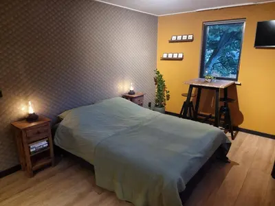 a bedroom with a bed and a desk and a window at Aan de Burgwal in Enkhuizen