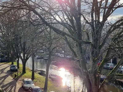 a flooded street with cars parked next to a river at Aan de Burgwal in Enkhuizen