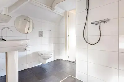 a white bathroom with a shower and a toilet at Hotel Stad en Land in Alkmaar