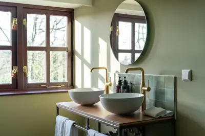 a bathroom with two sinks on a wooden counter with a mirror at Boetiekhotel De Kastanjehof in Lage-Vuursche