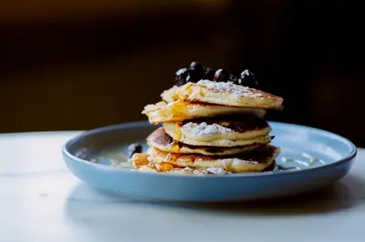 a stack of pancakes on a plate on a table at Boetiekhotel De Kastanjehof in Lage-Vuursche