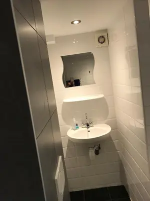 a small bathroom with a sink and a mirror at Apartment de Boer in Zandvoort