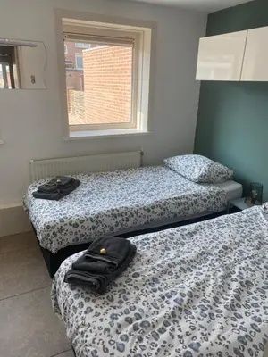 two beds sitting in a room with a window at Apartment de Boer in Zandvoort