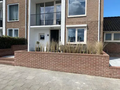 a brick retaining wall in front of a house at Apartment de Boer in Zandvoort