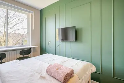 a bedroom with a bed with a television on the wall at Amsterdam Centraal in 10 minutes - nearby metro in Amsterdam