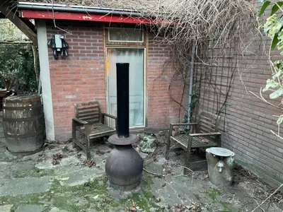 a brick house with two benches and a stove at Tiny house for 2 with private garden in Utrecht