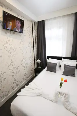 a bedroom with two beds with a tv on the wall at Hotel Flipper Amsterdam in Amsterdam