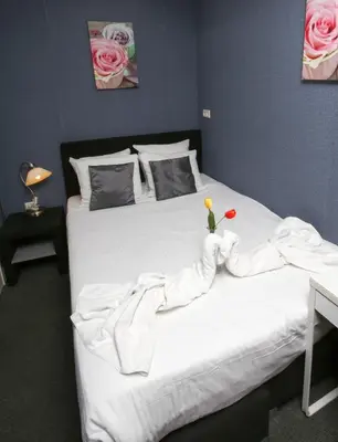 a bedroom with a white bed with a flower on it at Hotel Flipper Amsterdam in Amsterdam