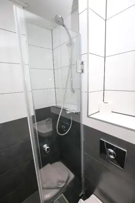 a bathroom with a shower with a toilet and a sink at Hotel Flipper Amsterdam in Amsterdam