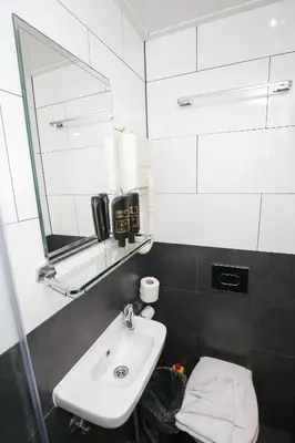 a bathroom with a sink and a mirror and a toilet at Hotel Flipper Amsterdam in Amsterdam