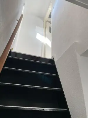 a staircase with black steps and a mirror at De Vrije Vogel in Egmond aan Zee