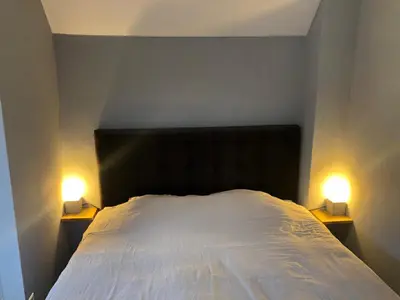 a bedroom with a bed with two lights on it at De Vrije Vogel in Egmond aan Zee