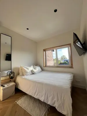 a bedroom with a white bed with a window at Tiny House in center Aalsmeer I Close to Schiphol & Amsterdam in Aalsmeer