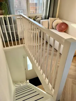 a white staircase with a couch in a living room at Tiny House in center Aalsmeer I Close to Schiphol & Amsterdam in Aalsmeer