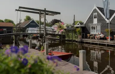 a boat is docked at a dock with a house at Tiny House in center Aalsmeer I Close to Schiphol & Amsterdam in Aalsmeer