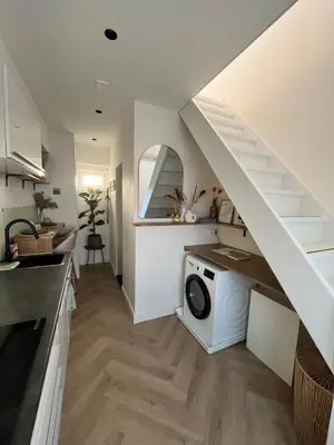 a kitchen with a washing machine under a staircase at Tiny House in center Aalsmeer I Close to Schiphol & Amsterdam in Aalsmeer