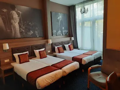 a hotel room with two beds and a chair at Hotel Washington in Amsterdam