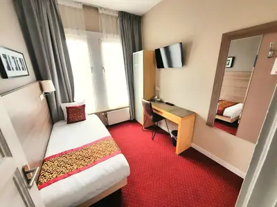 a hotel room with a bed and a desk and a mirror at Hotel Washington in Amsterdam