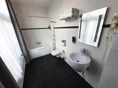 a white bathroom with a sink and a toilet at Hotel Washington in Amsterdam