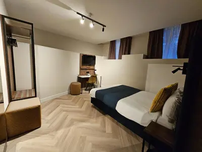 a bedroom with a bed and a mirror in it at Hotel Washington in Amsterdam
