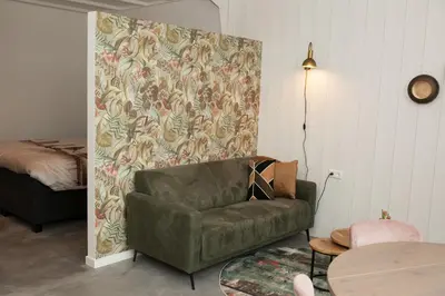 a living room with a green couch and a table at Het Groeneveld in Oudkarspel