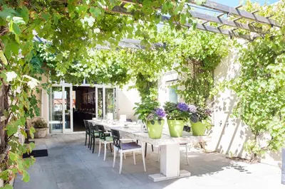 a patio with a table with plants on it at Hotel Victoria in Bergen aan Zee