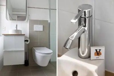 a bathroom with a sink and a toilet and a mirror at Hotel Victoria in Bergen aan Zee