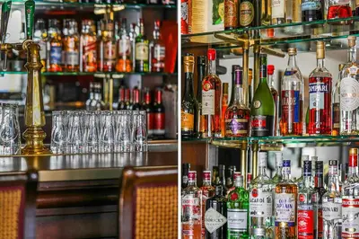 a bar with a lot of bottles of alcohol at Hotel Victoria in Bergen aan Zee