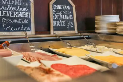 a buffet line with different types of food on display at Hotel Victoria in Bergen aan Zee