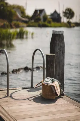 a basket sitting on a dock next to the water at De Durgerdam, Amsterdam in Amsterdam