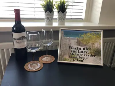 a bottle of wine and two glasses on a table at Sterflat 67 in Egmond aan Zee