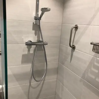 a shower with a shower head in a bathroom at Sterflat 67 in Egmond aan Zee