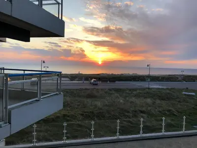 a sunset over a parking lot at an airport at Sterflat 67 in Egmond aan Zee